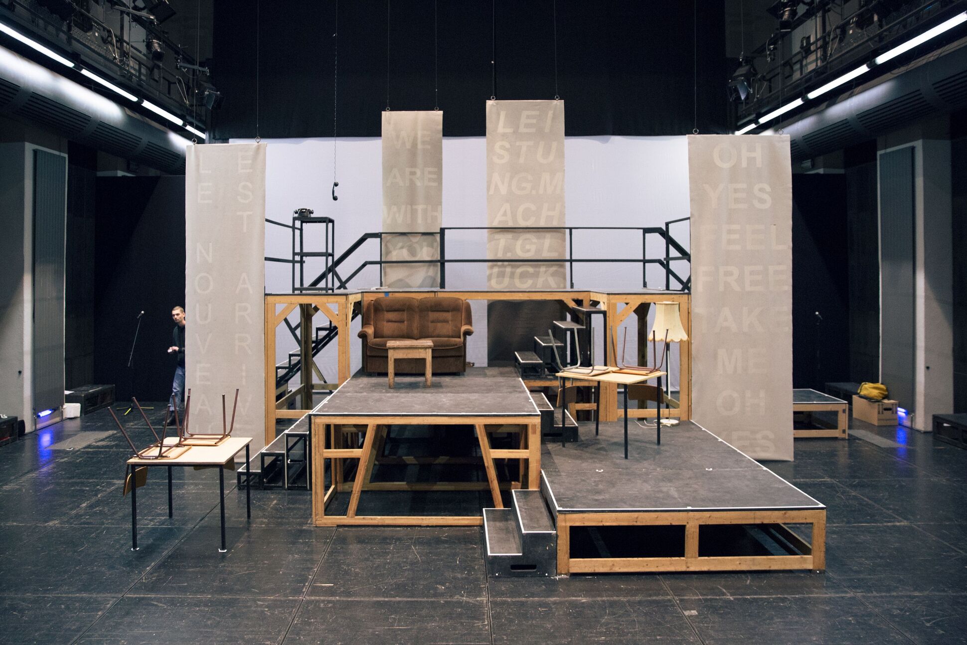 Bühnenbild: Verschiedene Möbel und Objekte auf der Bühne.
